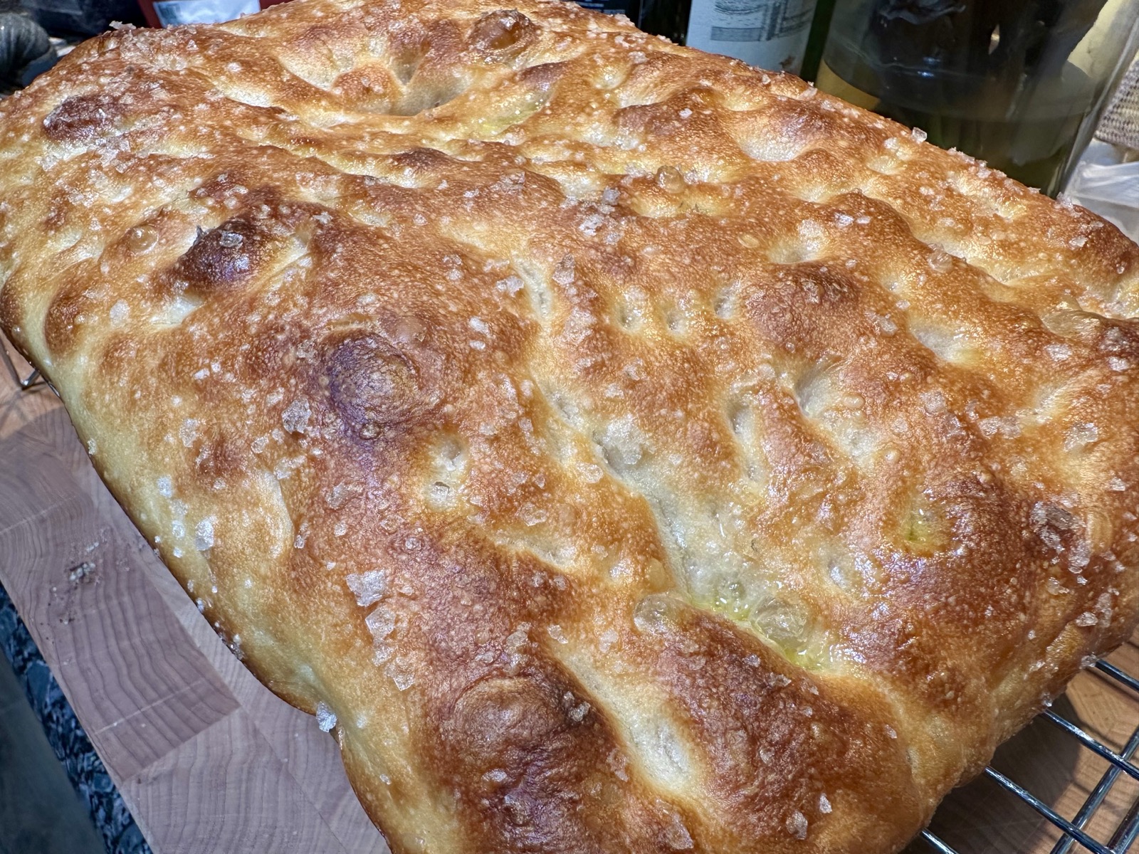 Close view of focaccia, fresh from the oven. It spreads before us like a delicious golden landscape.