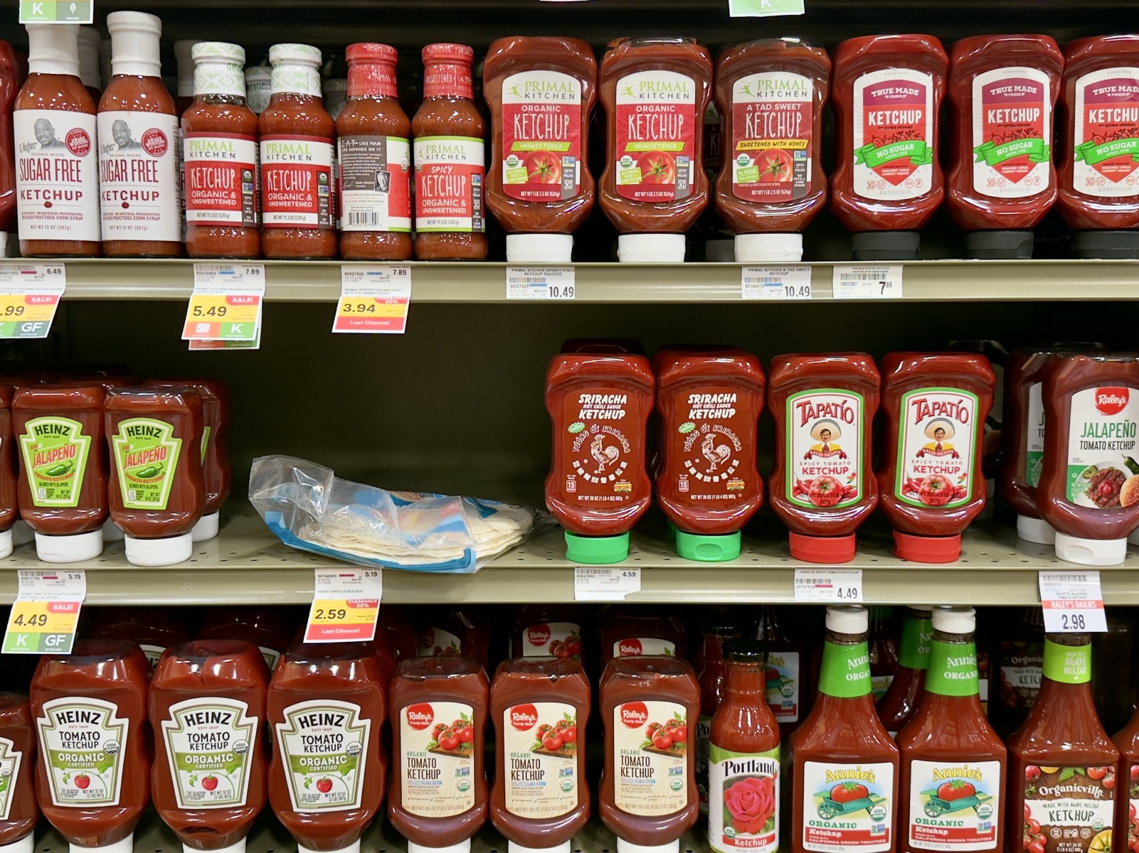 Ketchup, ordinary and fancier varieties on the shelf at the grocer.