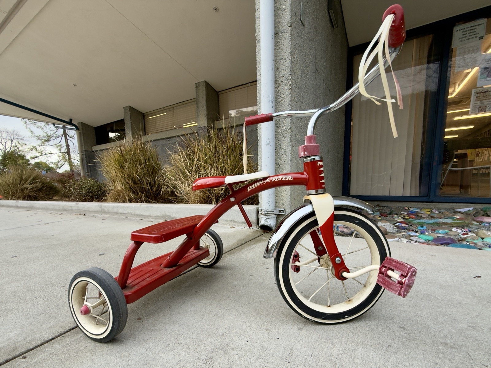 A child's red Radio Flyer tricycle.