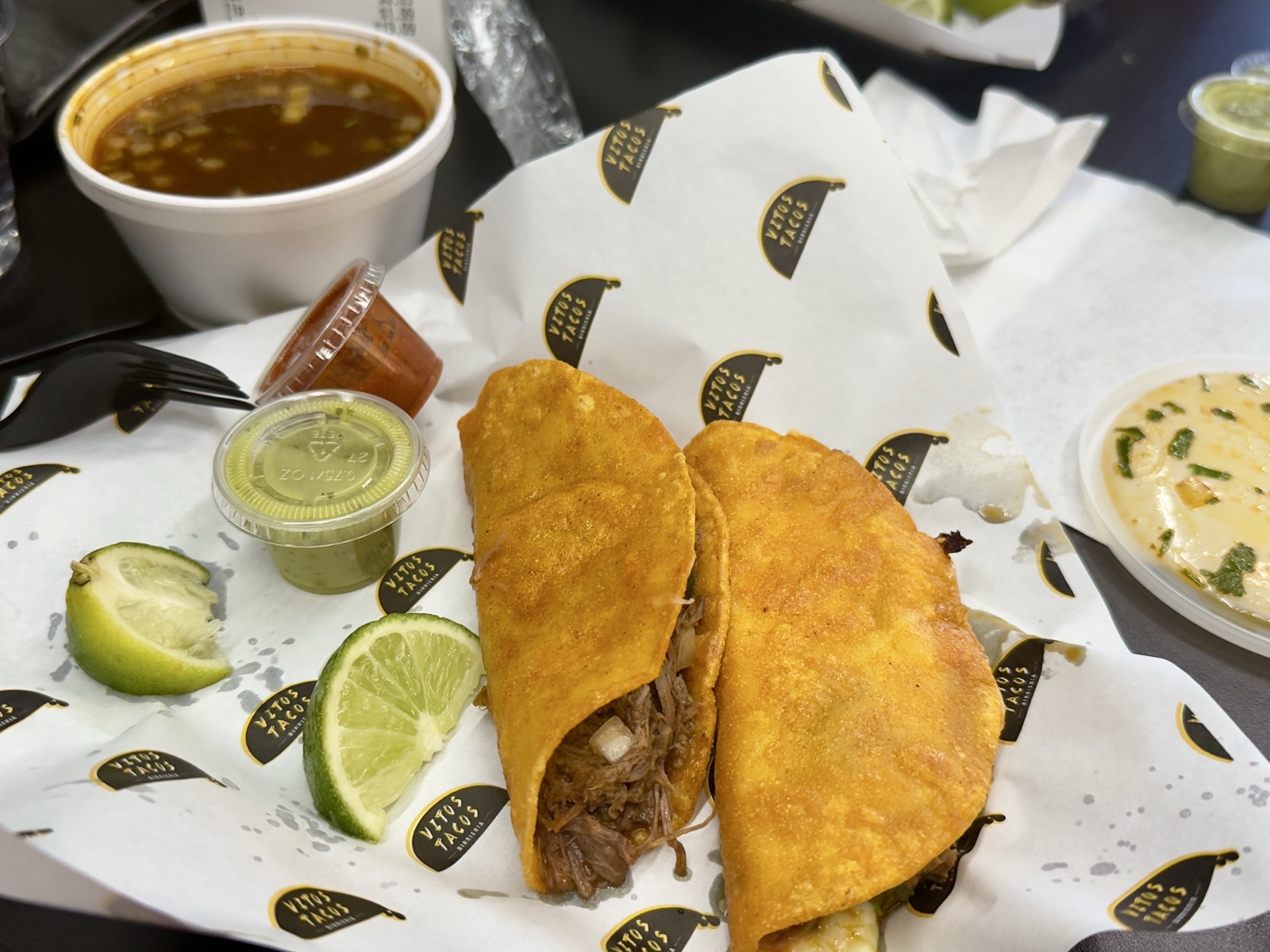 A plate of birria tacos and consomme.